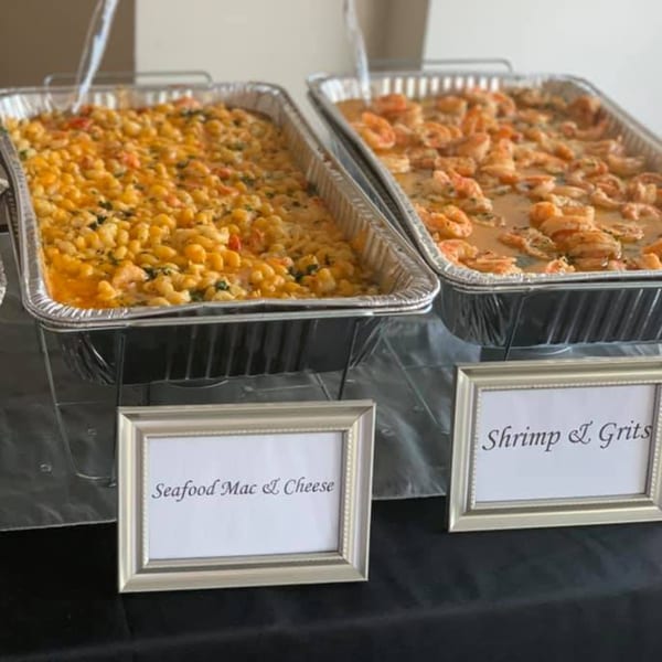 Two catering pans of Creole 2 Geaux's seafood mac and cheese and shrimp and grits.